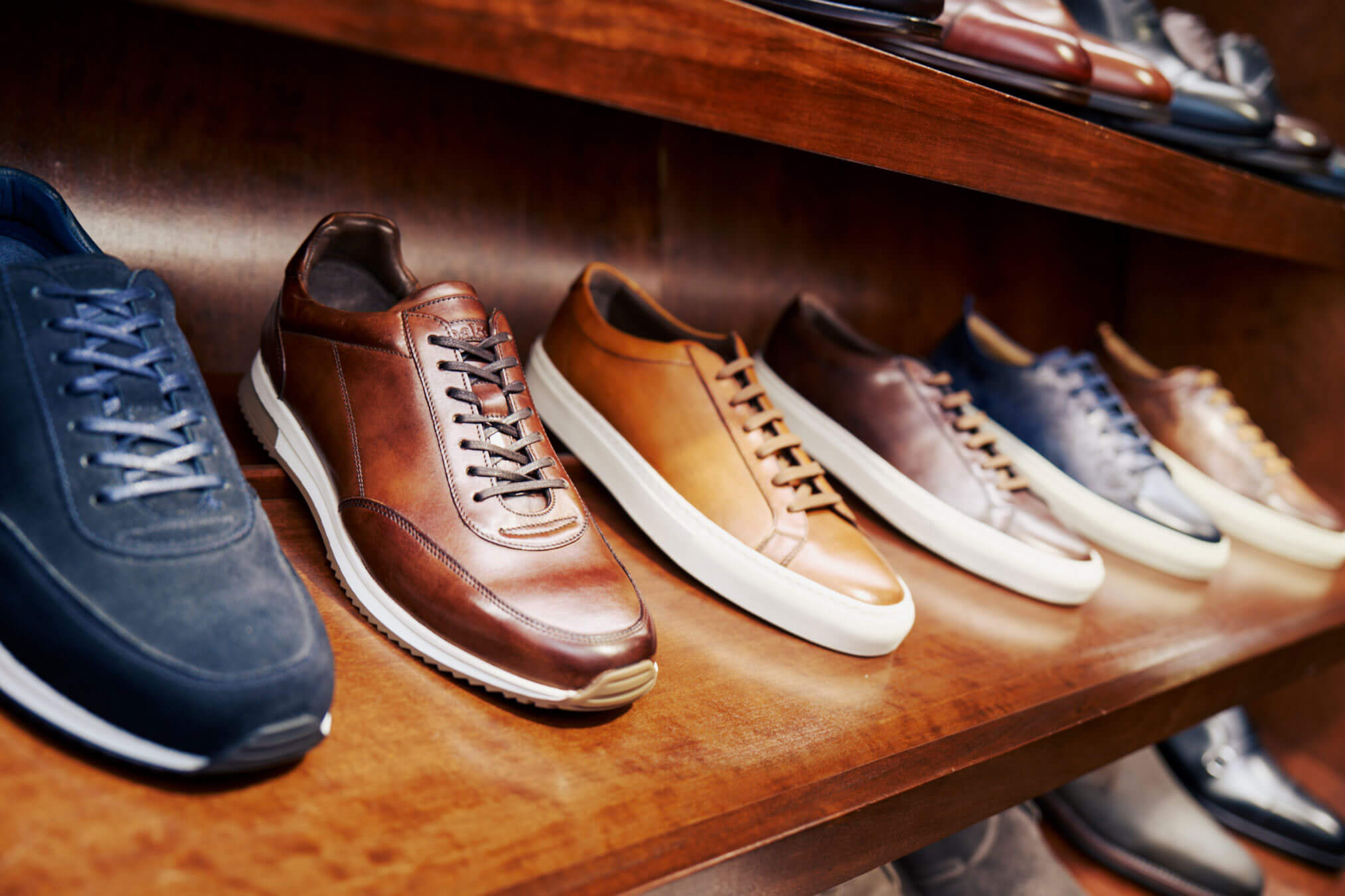 Formal sneakers in a range of colours on a wooden shelf